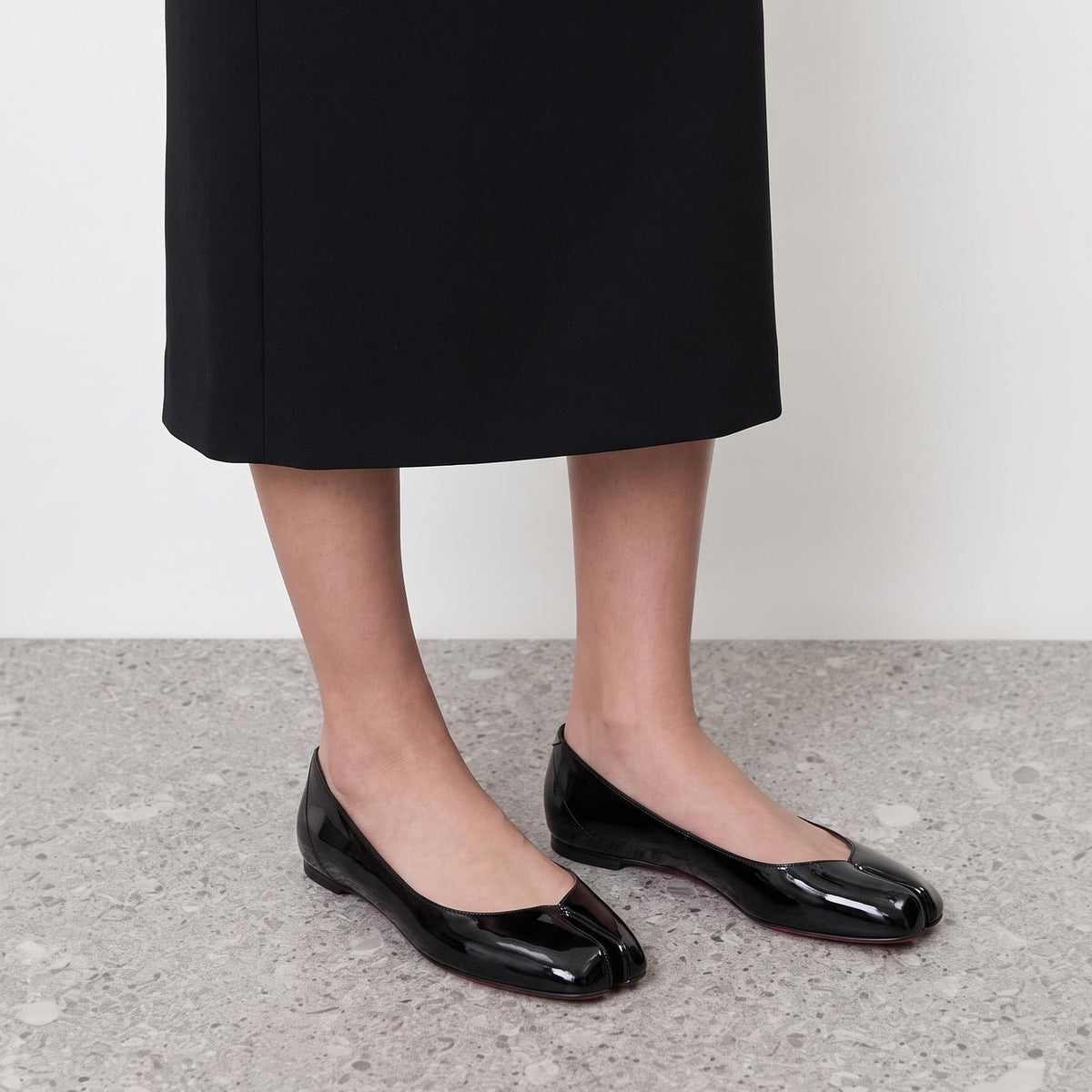 Echo Tabi Flats by Lil Cacti — black pair on model with a black midi skirt, three-quarter view