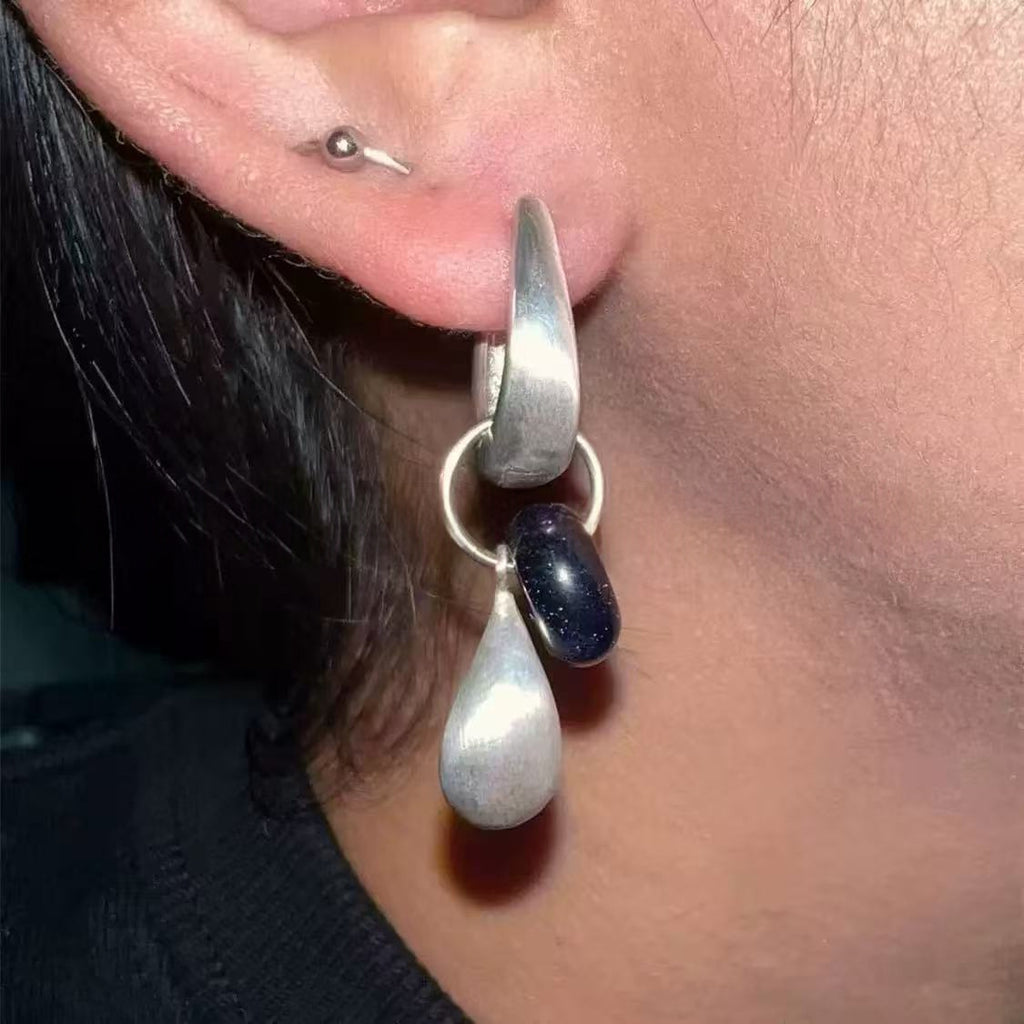 Close-up of the Dew Teardrop Charm Hoop Earrings, showing the finish and shape up close