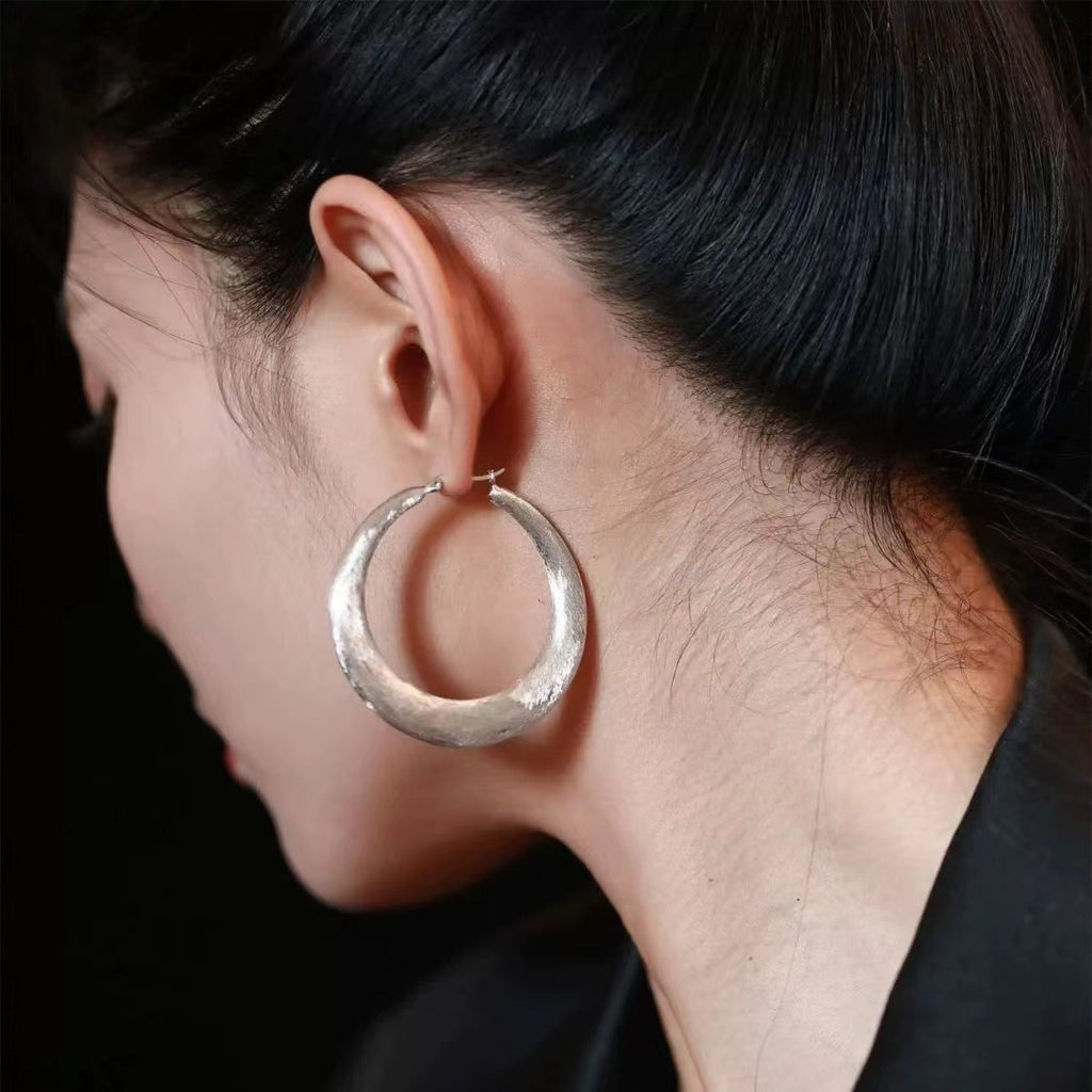 Tide Hammered Hoop Earrings worn on the ear, large hoop earrings