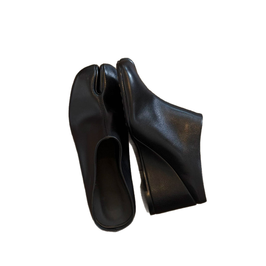 Close-up of black tabi wedge slides showing the split toe and wedge sole