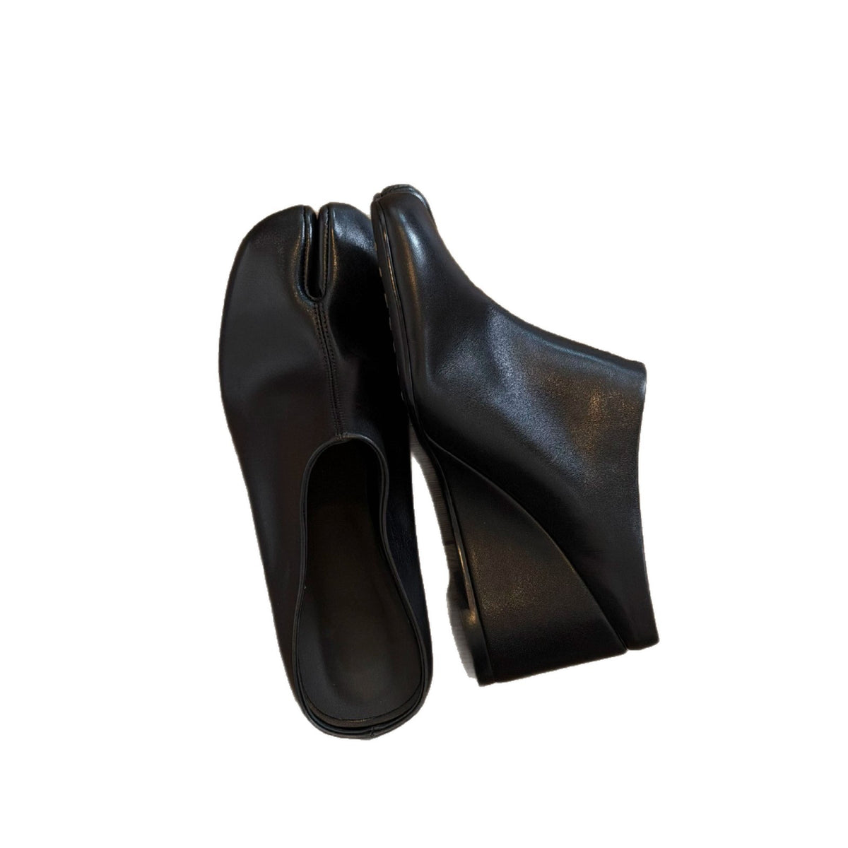 Close-up of black tabi wedge slides showing the split toe and wedge sole
