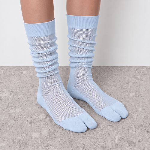 Light blue sheer mesh tabi socks worn slouched at the ankle
