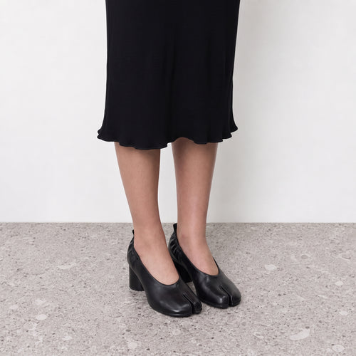 Amelora Black Leather Tabi Heels by Lil Cacti — on-model styled with a black ribbed midi skirt, tabi heels from the front