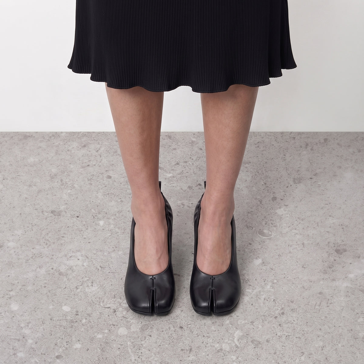 Front view on the foot of black tabi pumps showing the divided toe