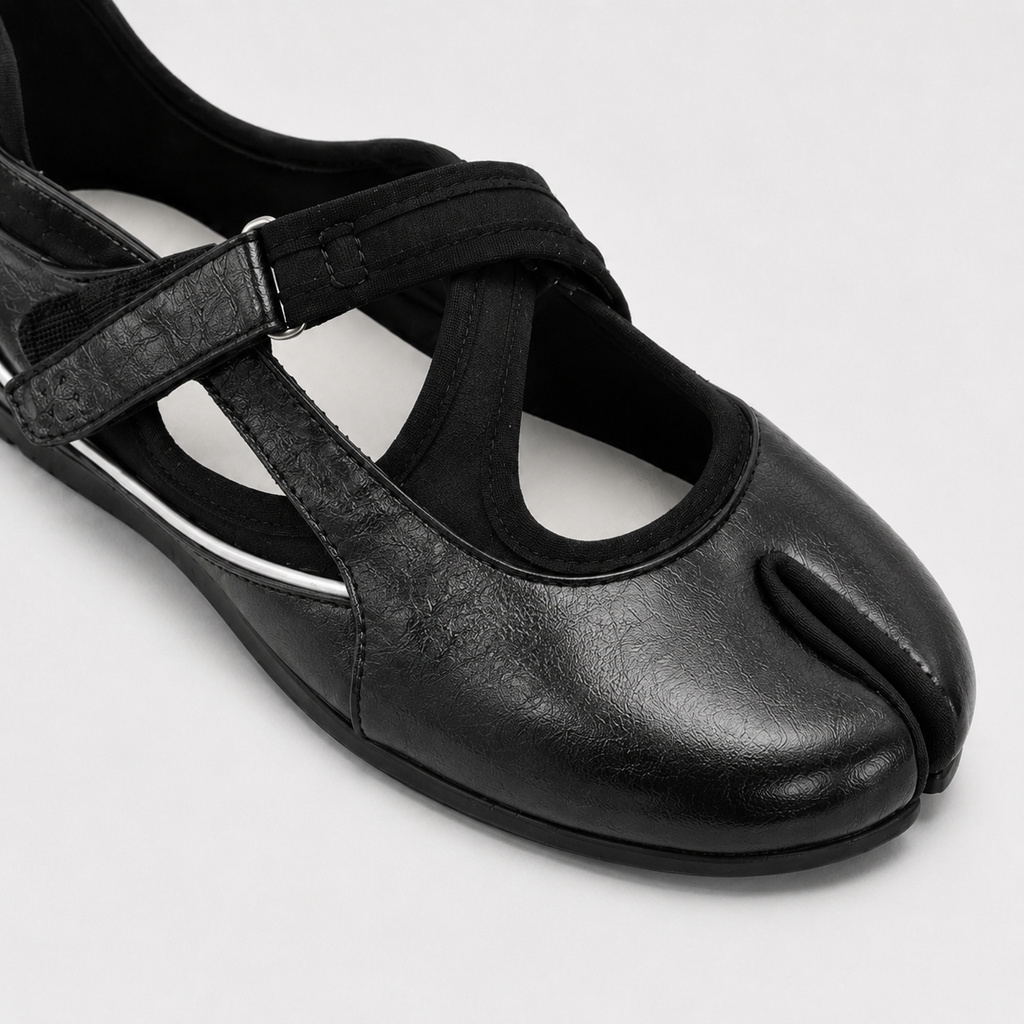 Three quarter view of black cross strap tabi flats showing the low side profile