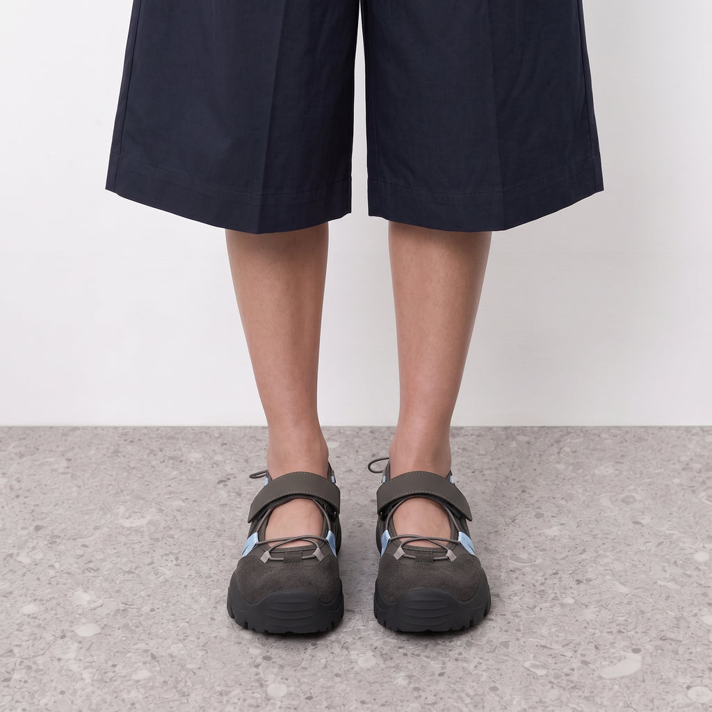 Front view on the foot of grey mary jane sneakers with blue bungee lacing