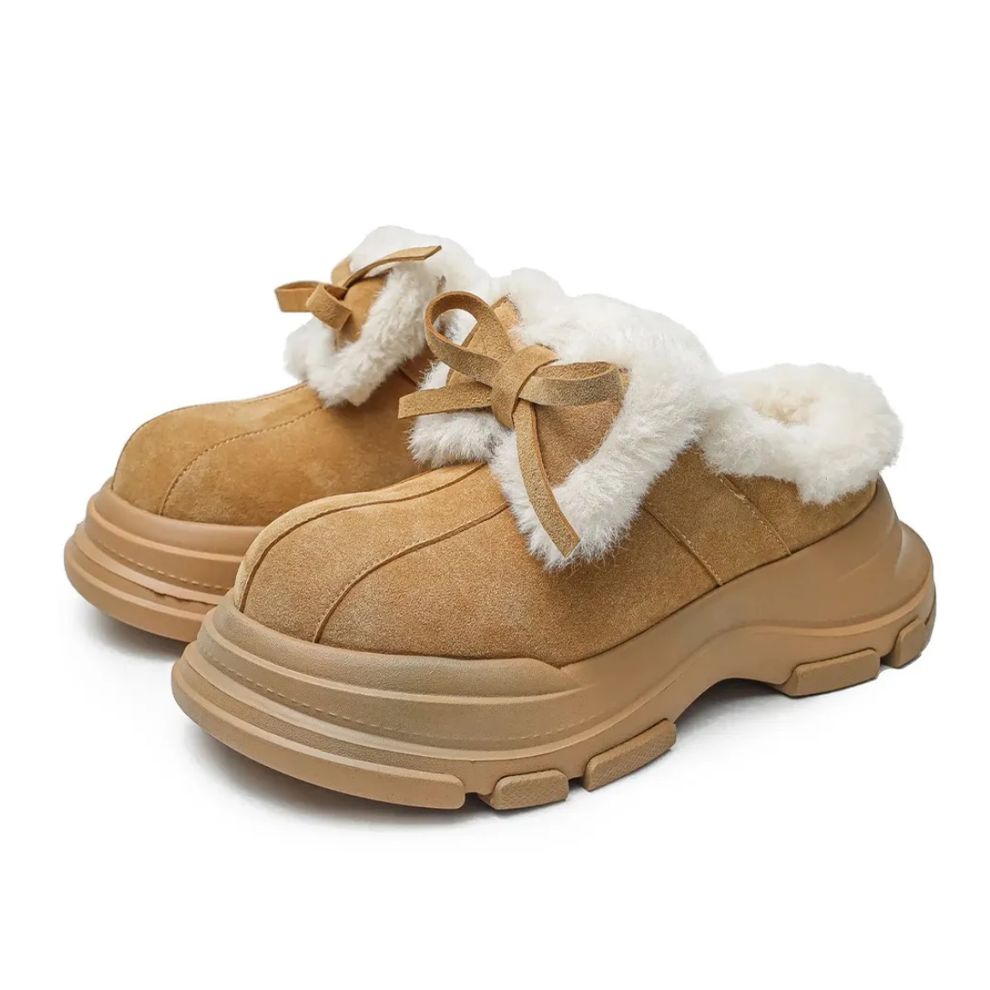 Tan slip-on shoes with white fur trim on a white background