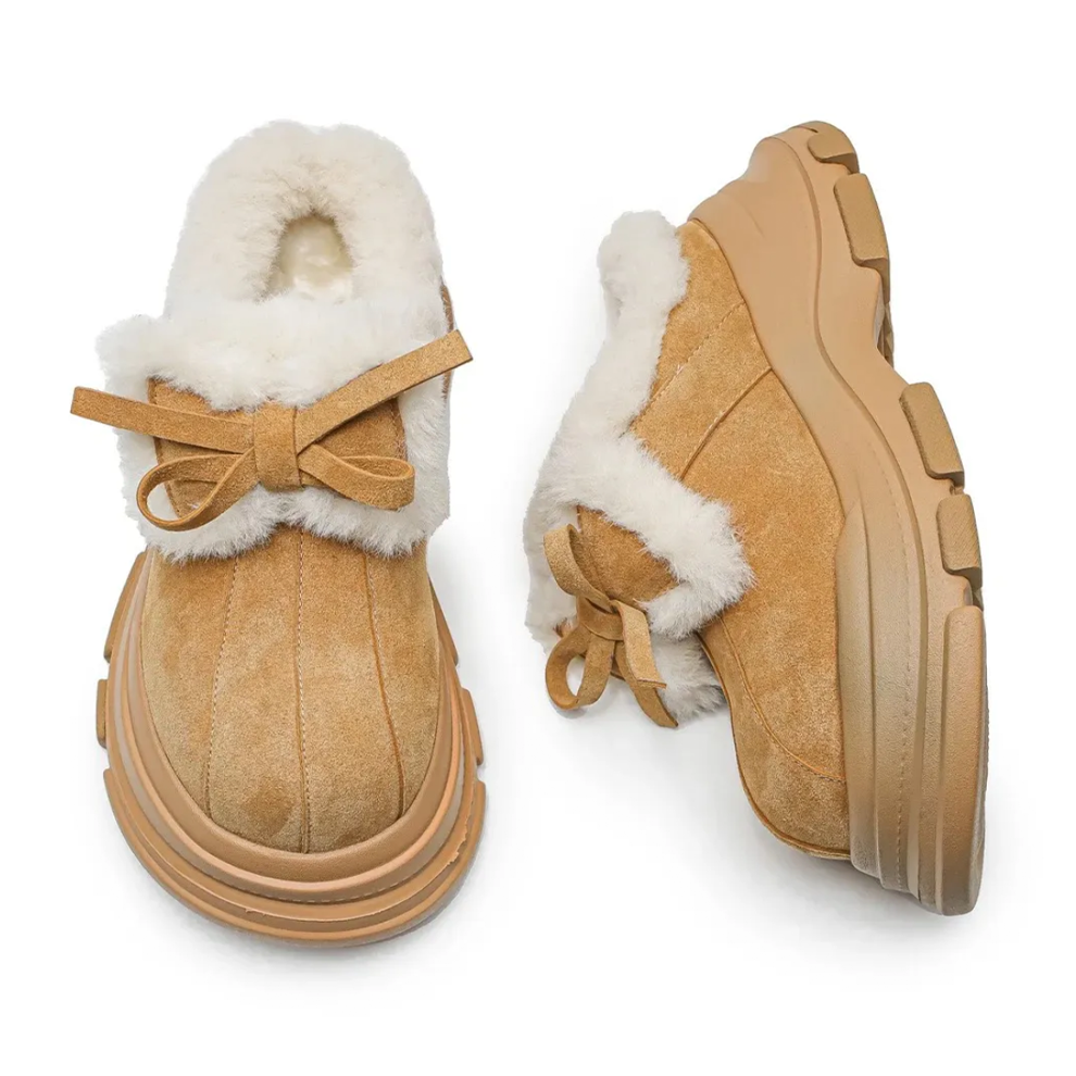 Tan suede boots with white fur lining on a white background