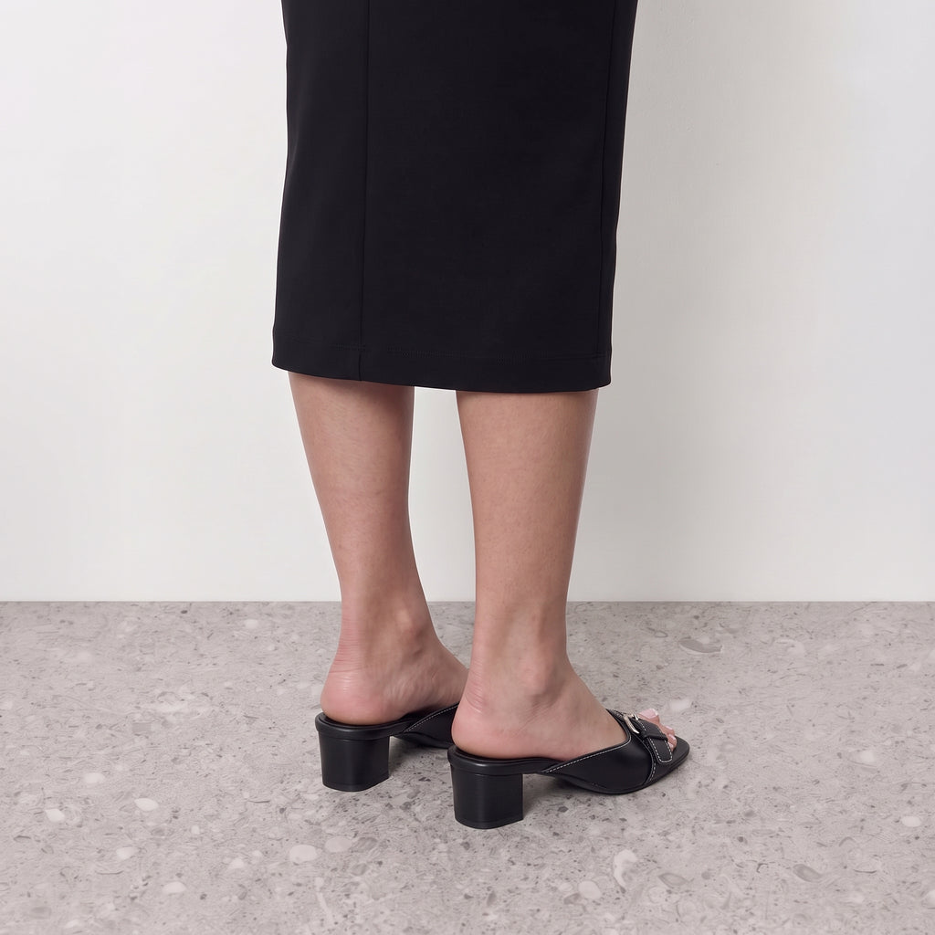 Model standing in Lil Cacti Belvra buckle mule heels
