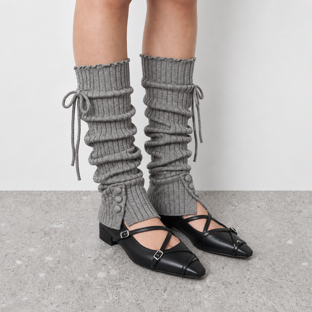 Model wearing grey leg warmers over ballet flats with cross straps