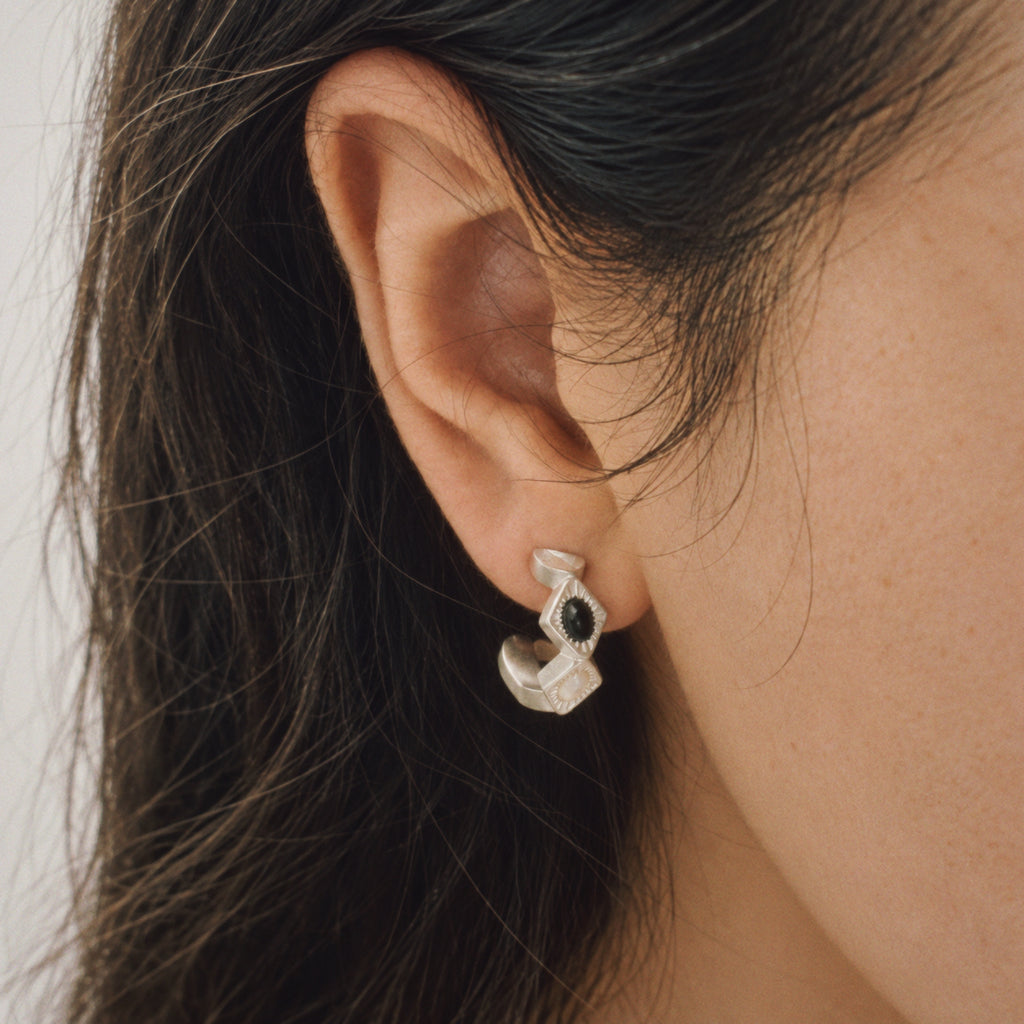 Model wearing the Bolt Zigzag Hoop Earrings from a side angle, black and white earrings