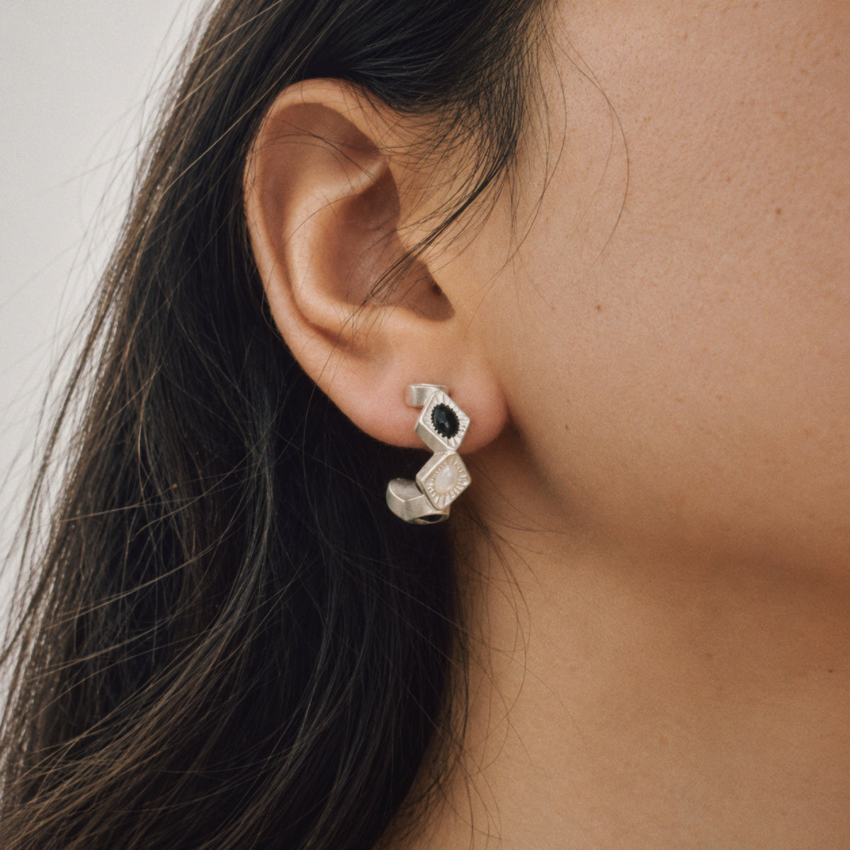 Model wearing the Bolt Zigzag Hoop Earrings, three quarter view, statement earrings