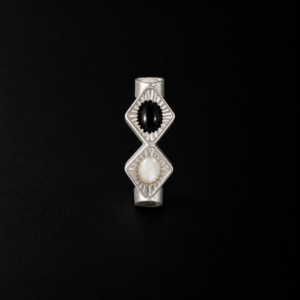 Close detail of the Bolt Zigzag Hoop Earrings surface and finish, black and white earrings