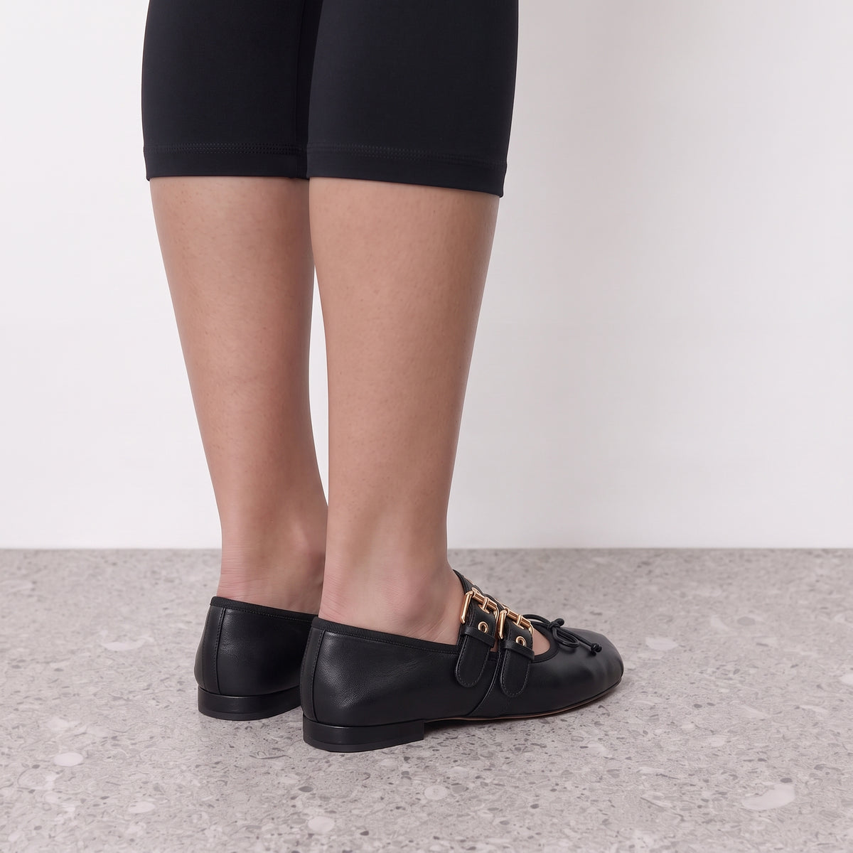 Back view of black Clara ballet flats on the foot showing the low heel and soft topline