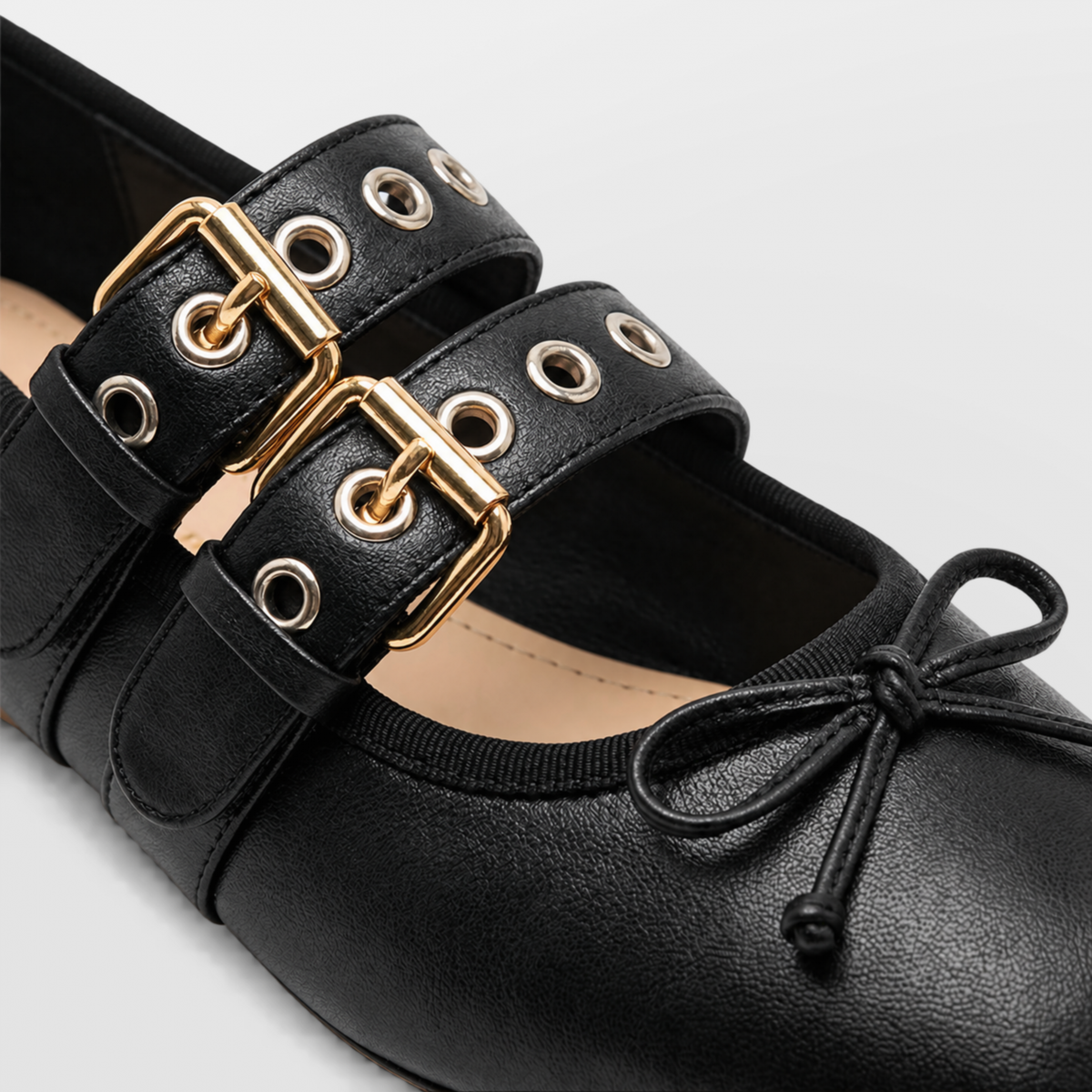 Close crop of the gold double buckles, eyelets and cord bow on a Lil Cacti Clara ballet flat