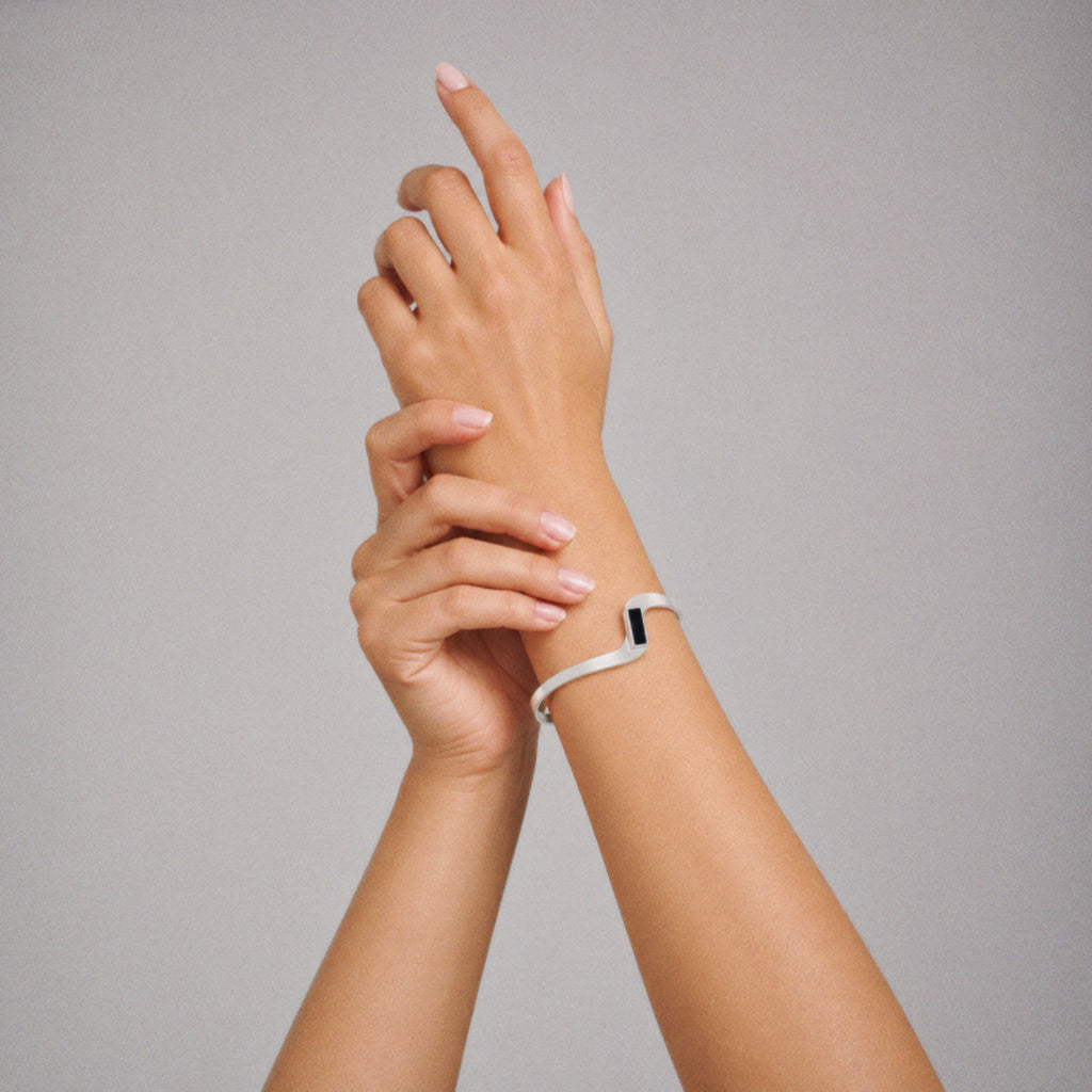 Model wearing the Crest Wave Cuff Bracelet in soft daylight