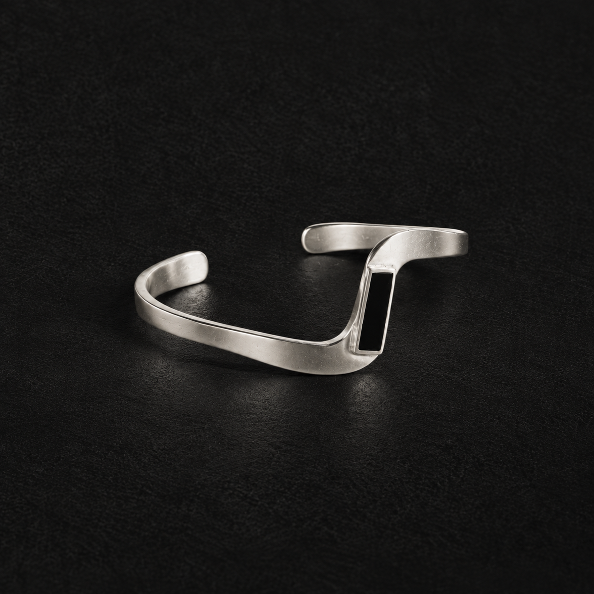 Pair of Crest Wave Cuff Bracelet angled together on a dark background