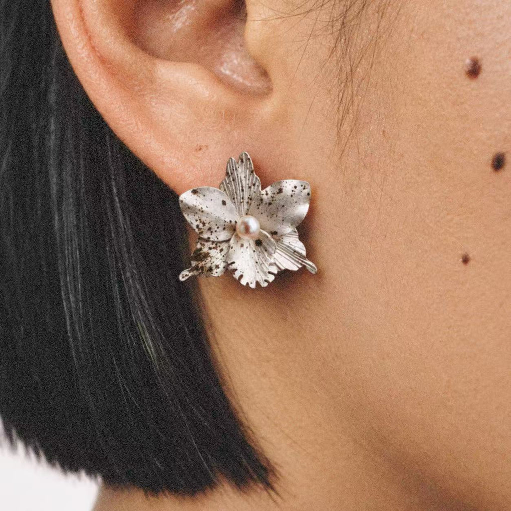 Model wearing the Crushed Orchid Earrings in a relaxed pose