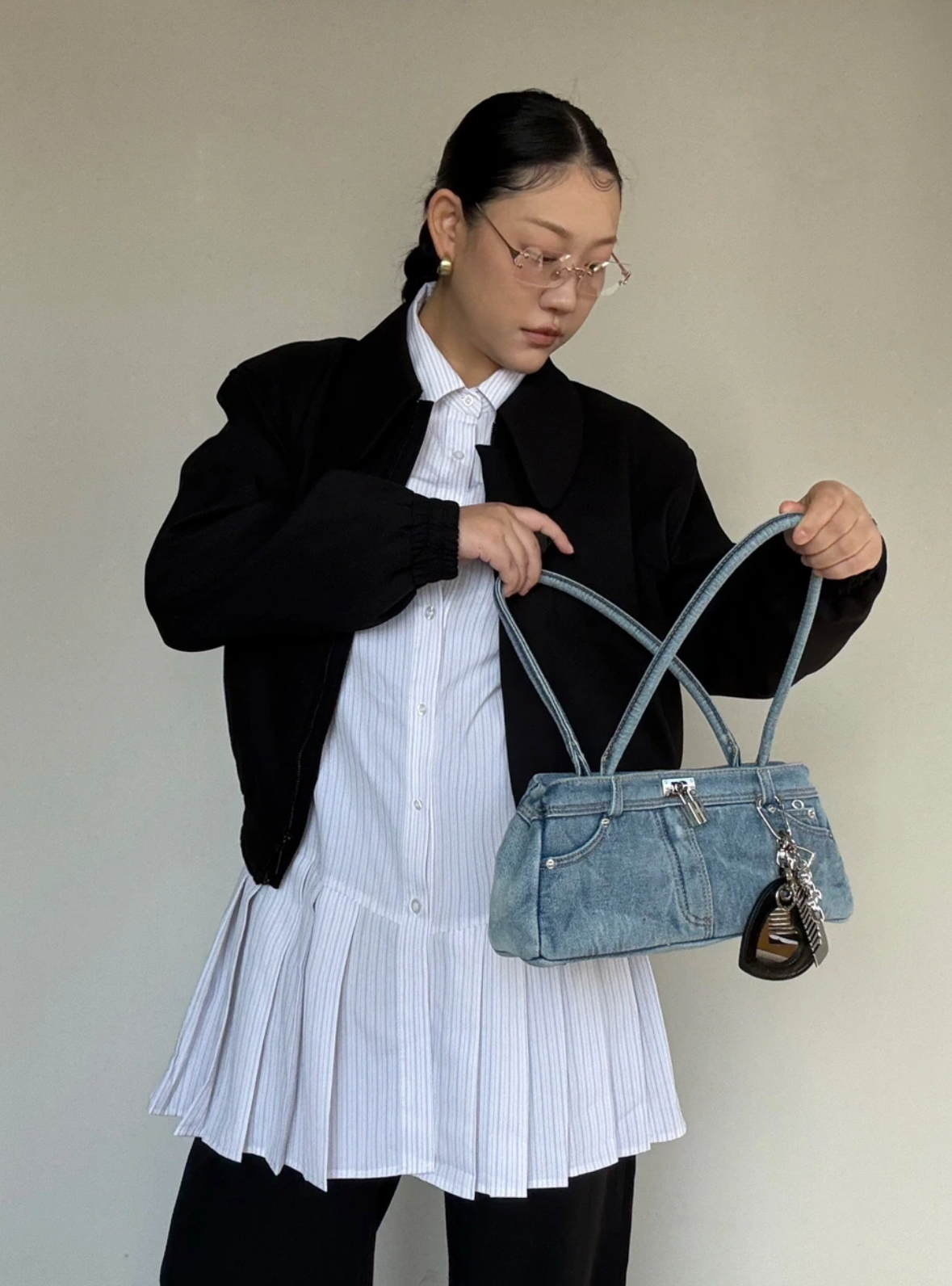 Person holding a Denim Daze Baguette Bag against a plain background