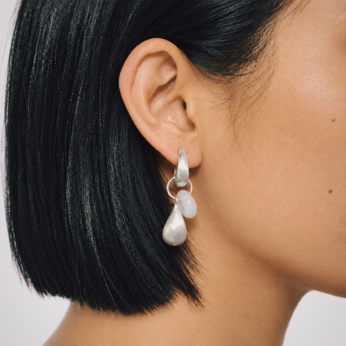 Model wearing Dew Teardrop Charm Hoop Earrings by Lil Cacti, view 1