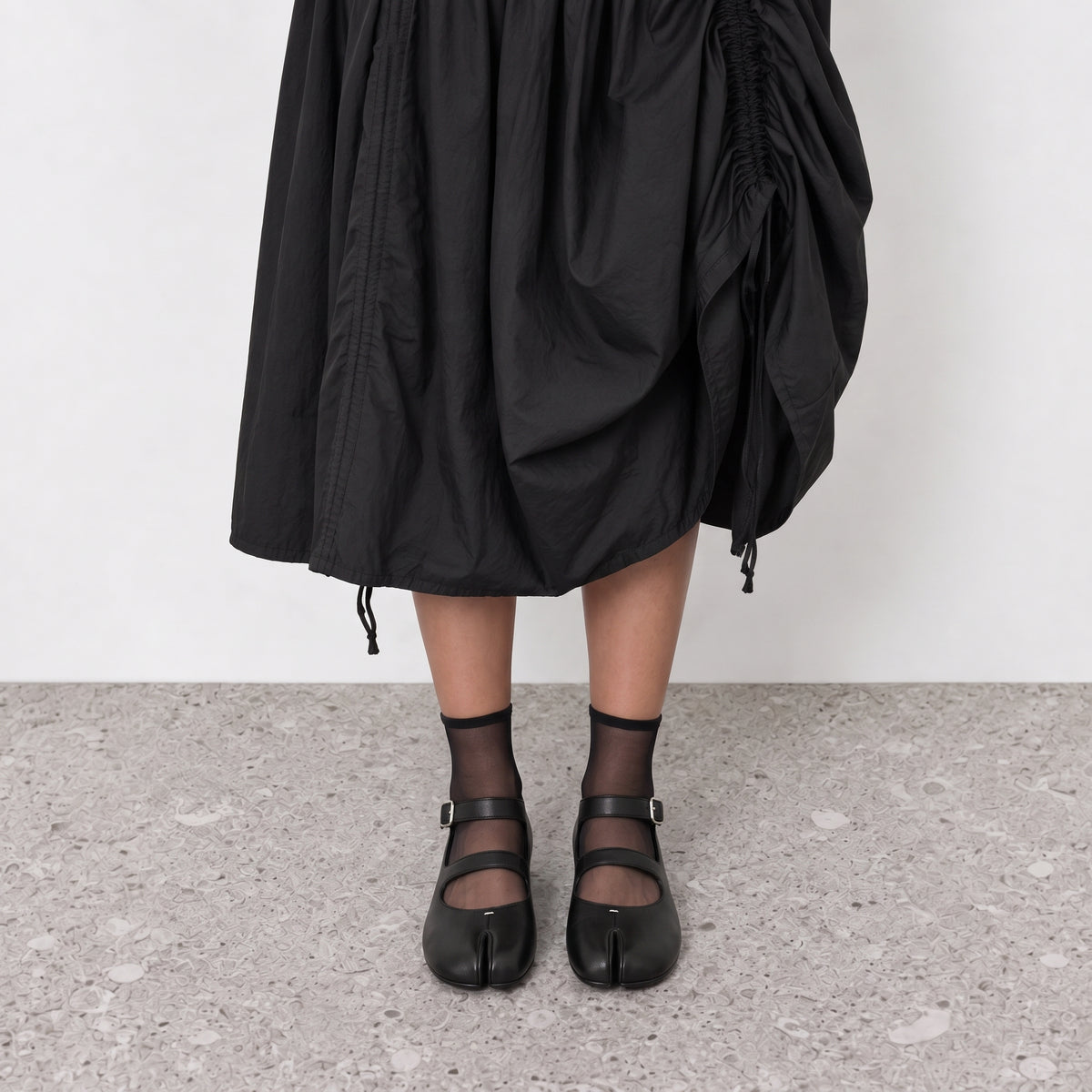Front view on the foot of black double strap tabi flats showing the divided toe