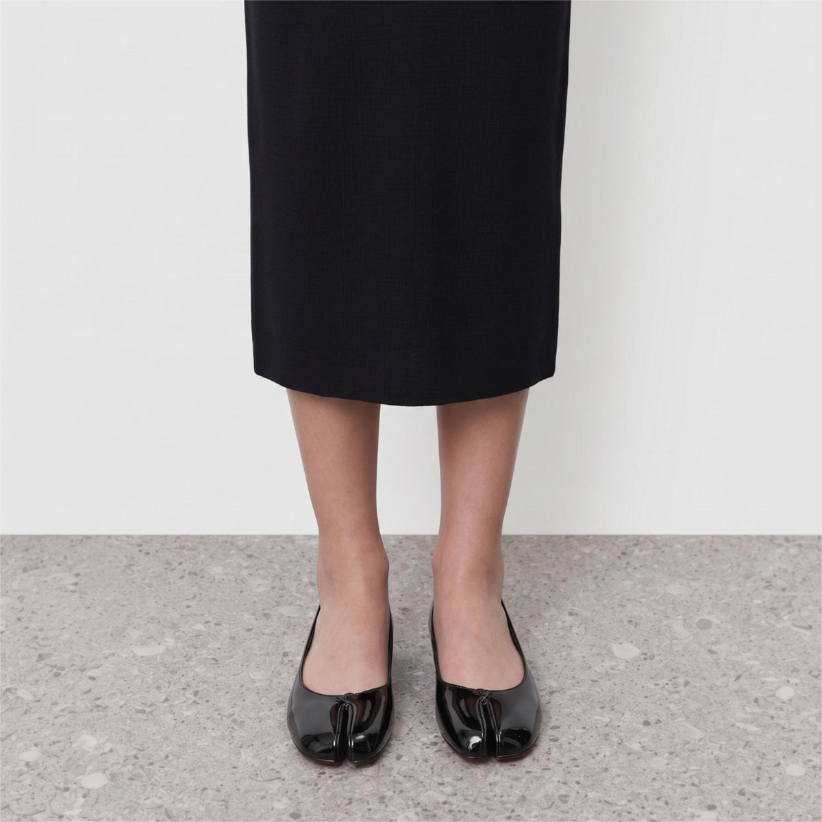 Front view on the foot of black patent tabi flats showing the divided toe