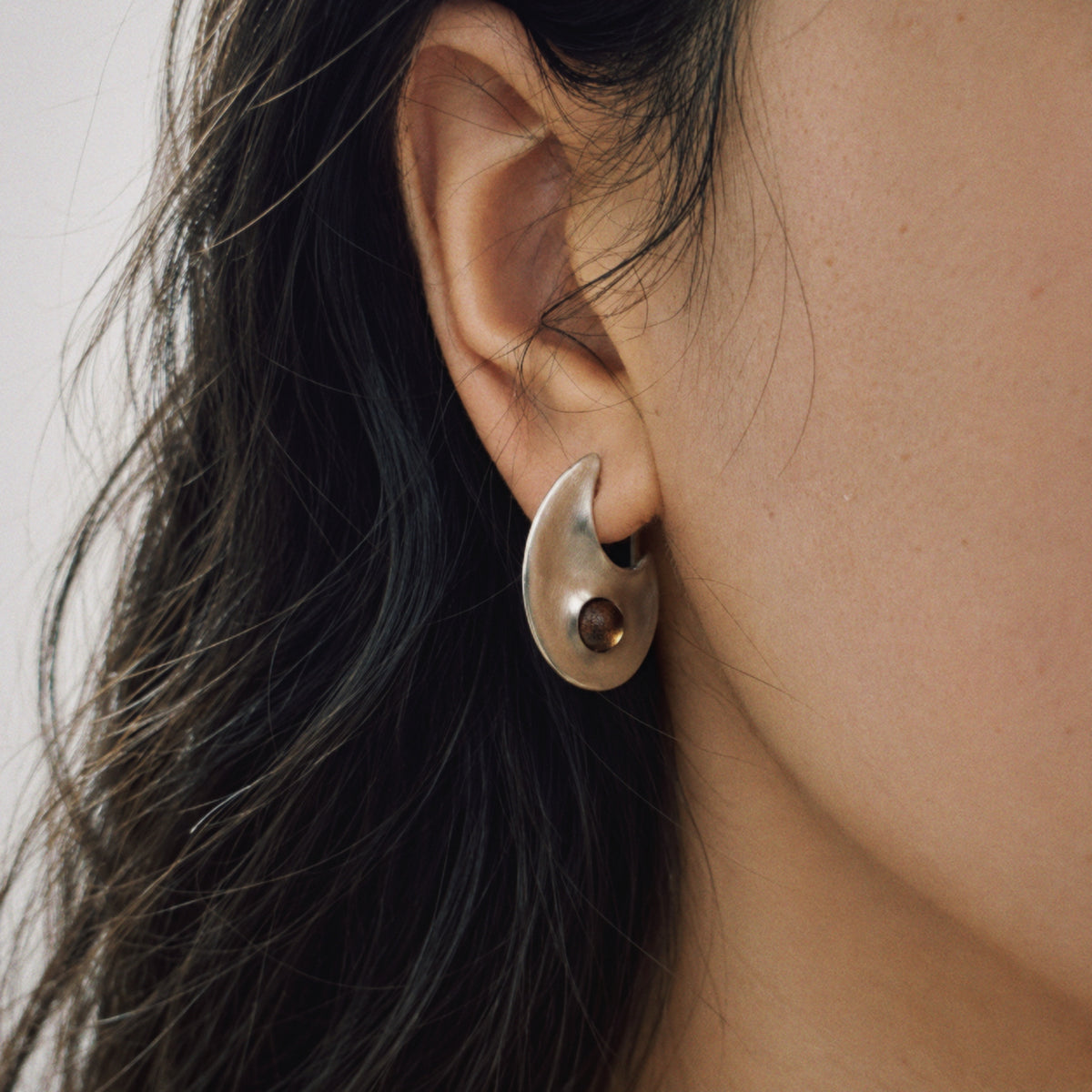 Model wearing Lil Cacti Eclipse Crescent Stud Earrings, close crop on the detail