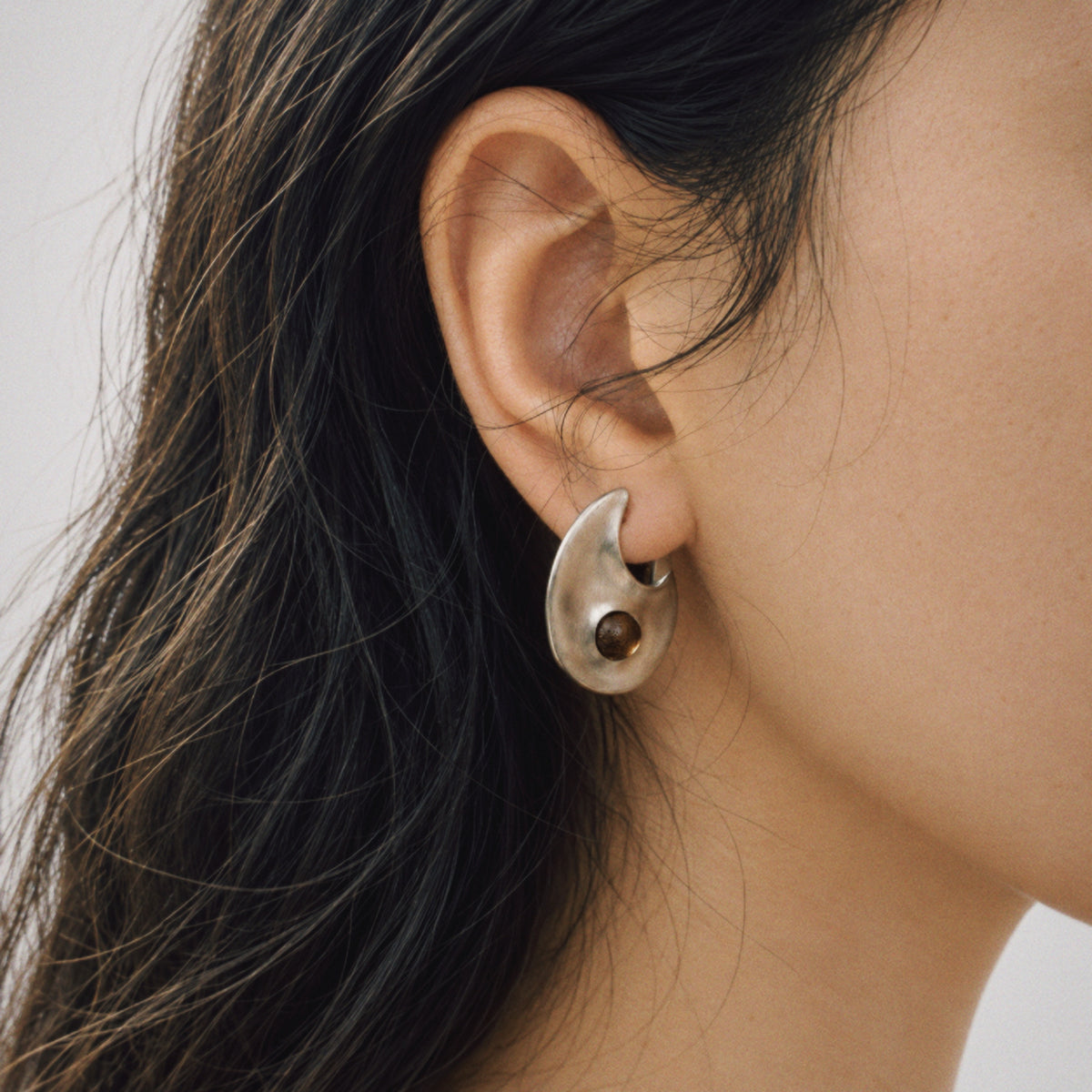 Model wearing the Eclipse Crescent Stud Earrings from a side angle
