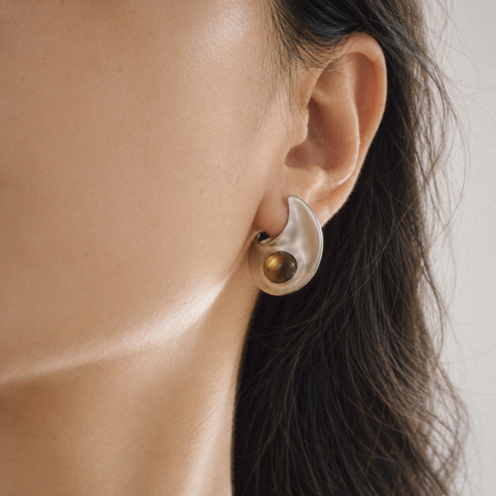 Model wearing the Eclipse Crescent Stud Earrings, three quarter view