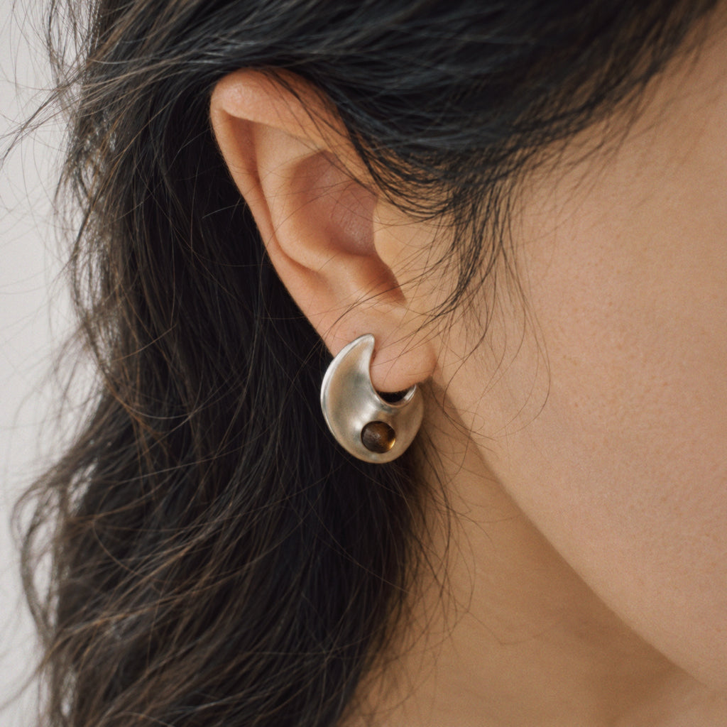 Model wearing the Eclipse Crescent Stud Earrings in soft daylight