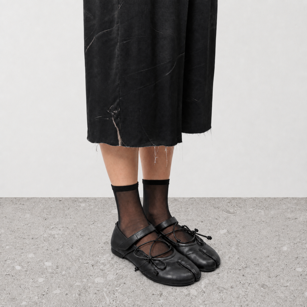 Top down view of black tabi ballet flats showing the laced vamp and split toe