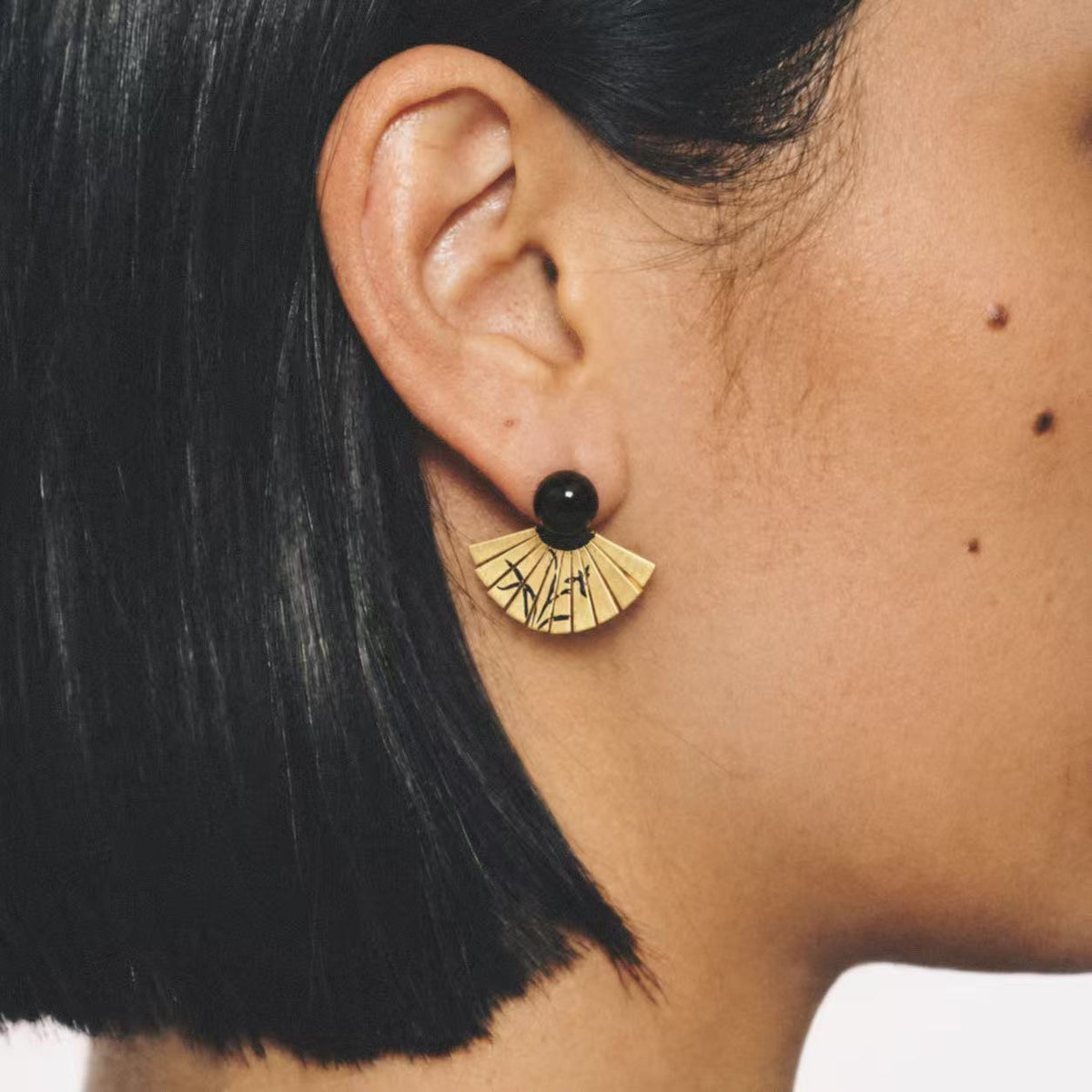 Model wearing the Etched Fan Drop Earrings seen from the front