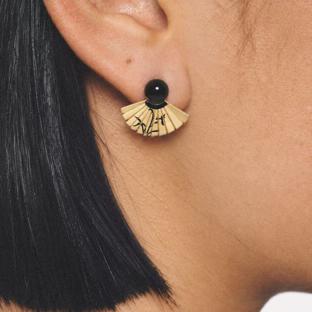 Model wearing the Etched Fan Drop Earrings seen from the side