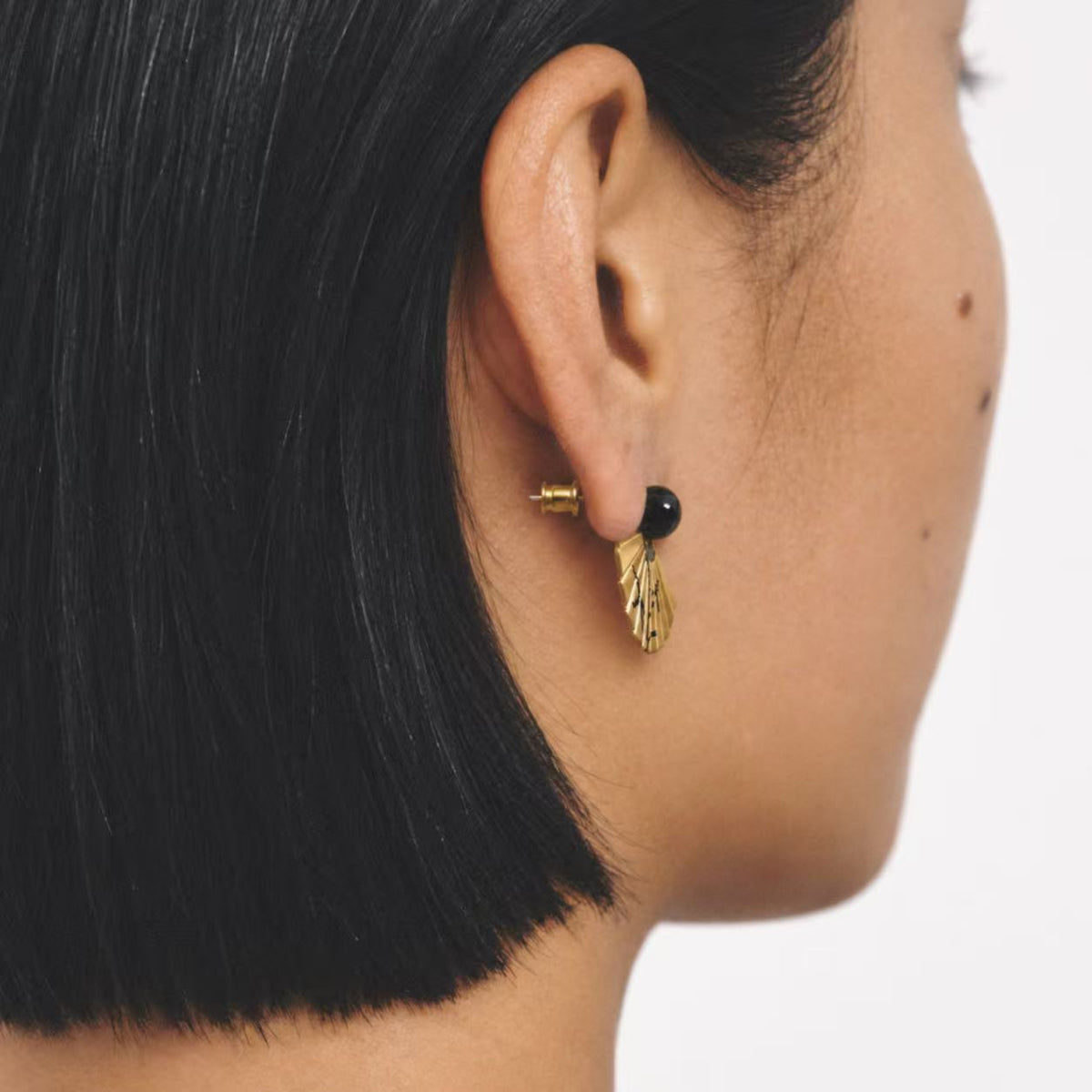 Model wearing the Etched Fan Drop Earrings seen from behind