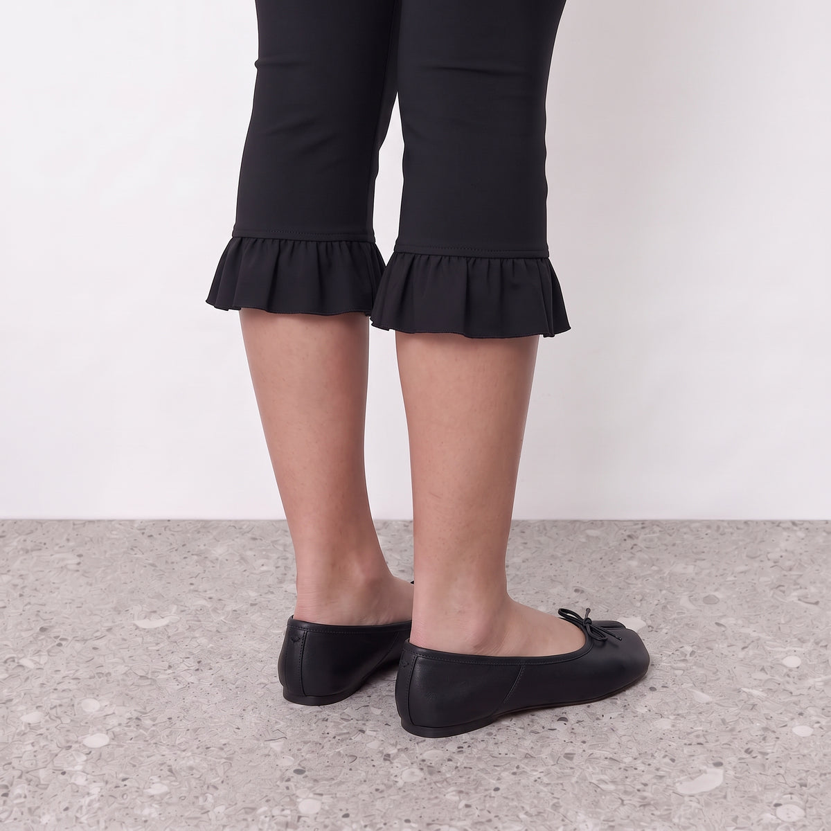 Model standing in Lil Cacti Evelyne black satin tabi ballet flats