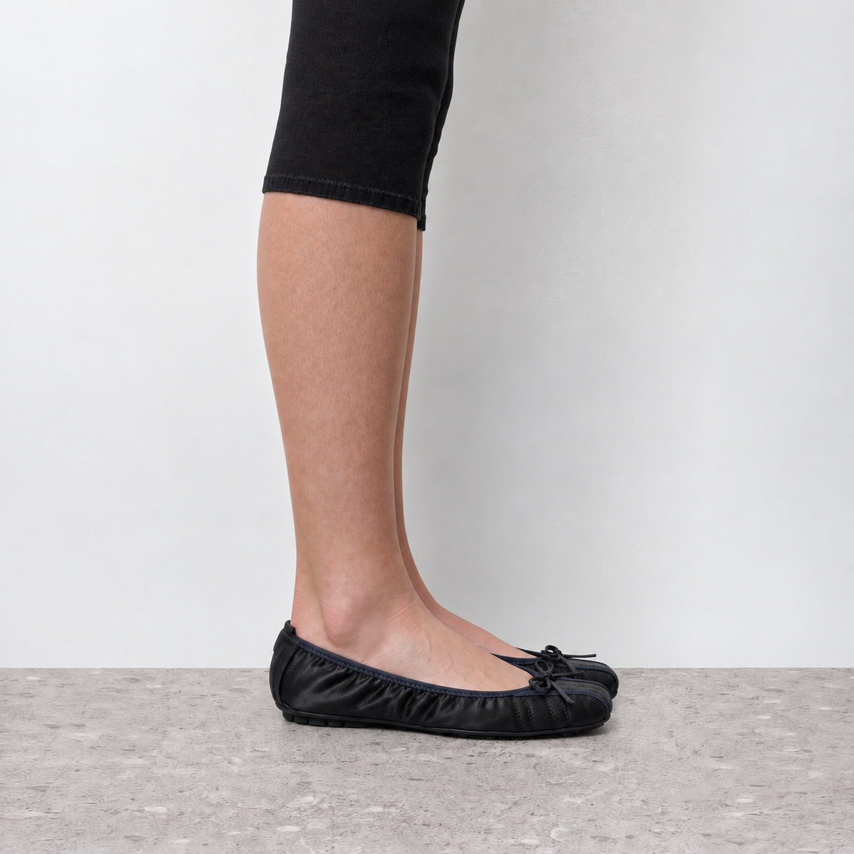 Model wearing Faye Ruched Bow Ballet Flats in black, full-length product styling view