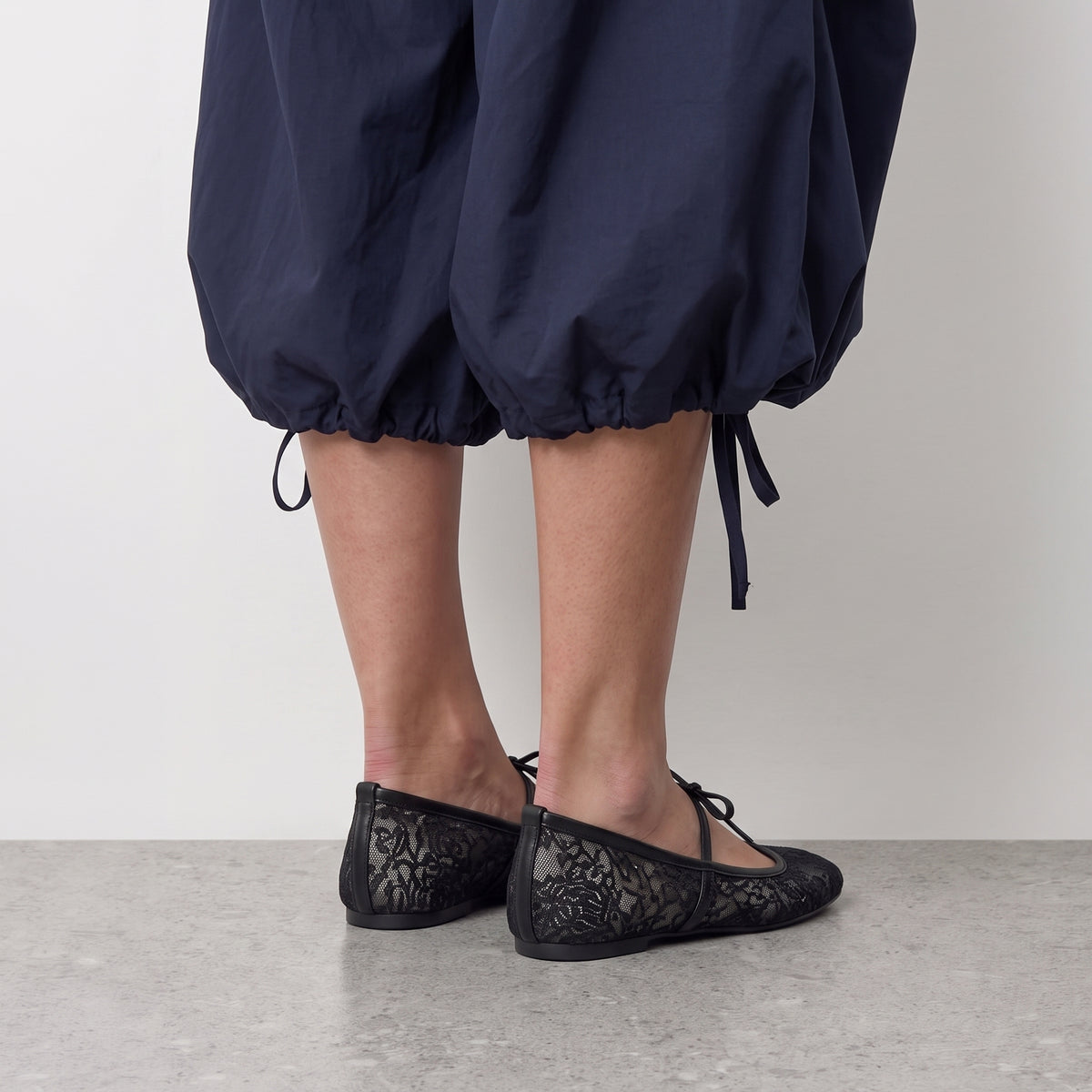Model standing in Lil Cacti Florence black lace ballet flats