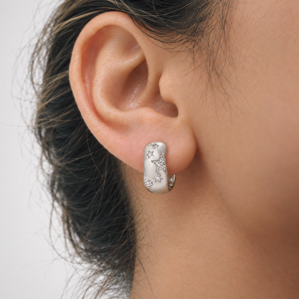 Model wearing Lil Cacti star huggie earrings in a close detail view
