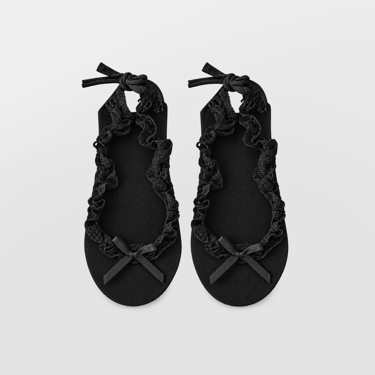 Pair of black ruffle ballet socks laid flat with bows and lace trim