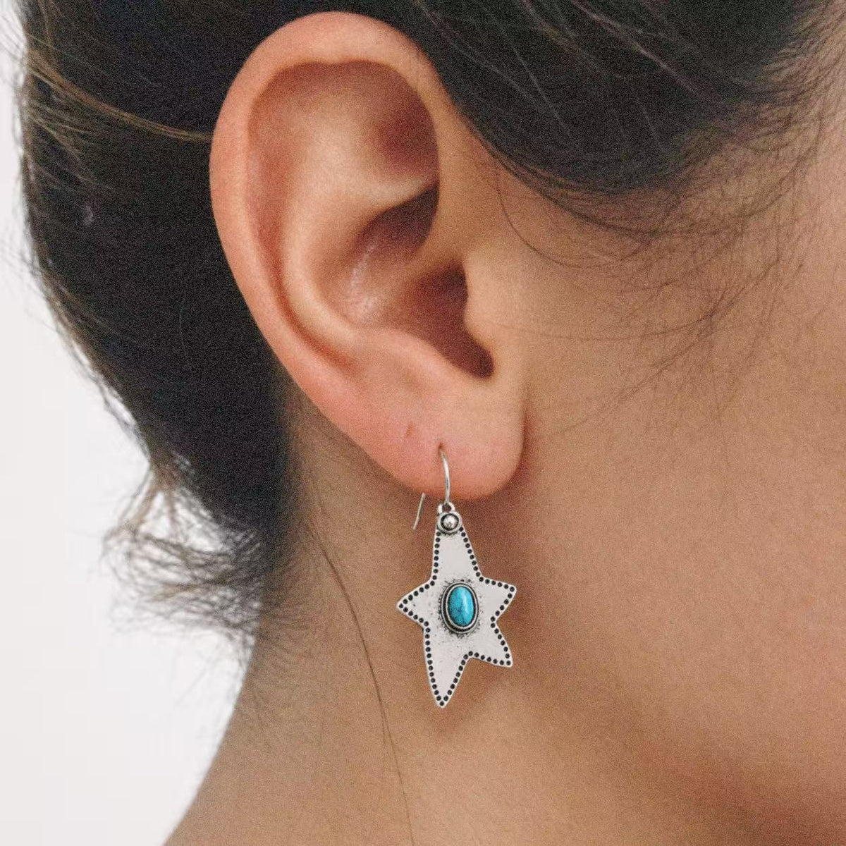 Halcyon Western Star Earrings worn on the ear, star earrings