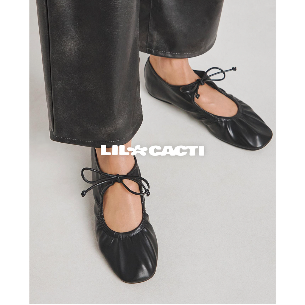 Iselle black ballet flats side profile showing ruched leather upper and flat sole — Lil Cacti
