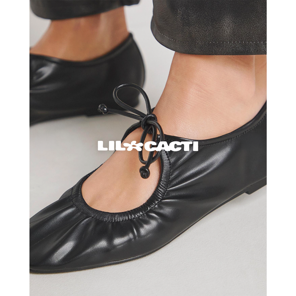 Close-up of black cord bow lace detail on Iselle mary jane ballet flats, ruched leather vamp