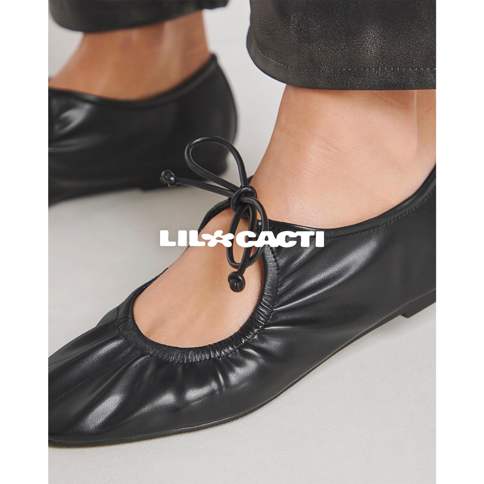 Close-up of black cord bow lace detail on Iselle mary jane ballet flats, ruched leather vamp