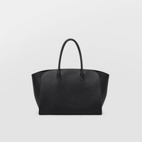 Model carrying a large black Lil Cacti leather tote over one shoulder
