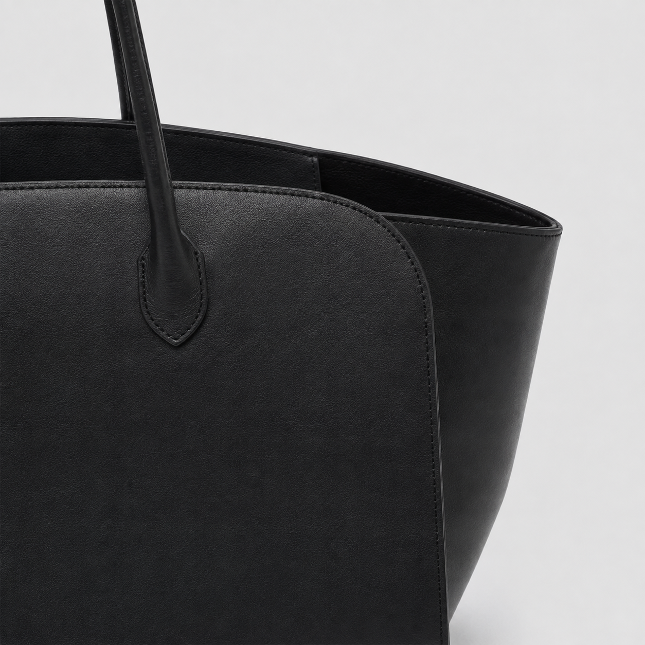 Detail of the smooth black leather body and stitched handle join