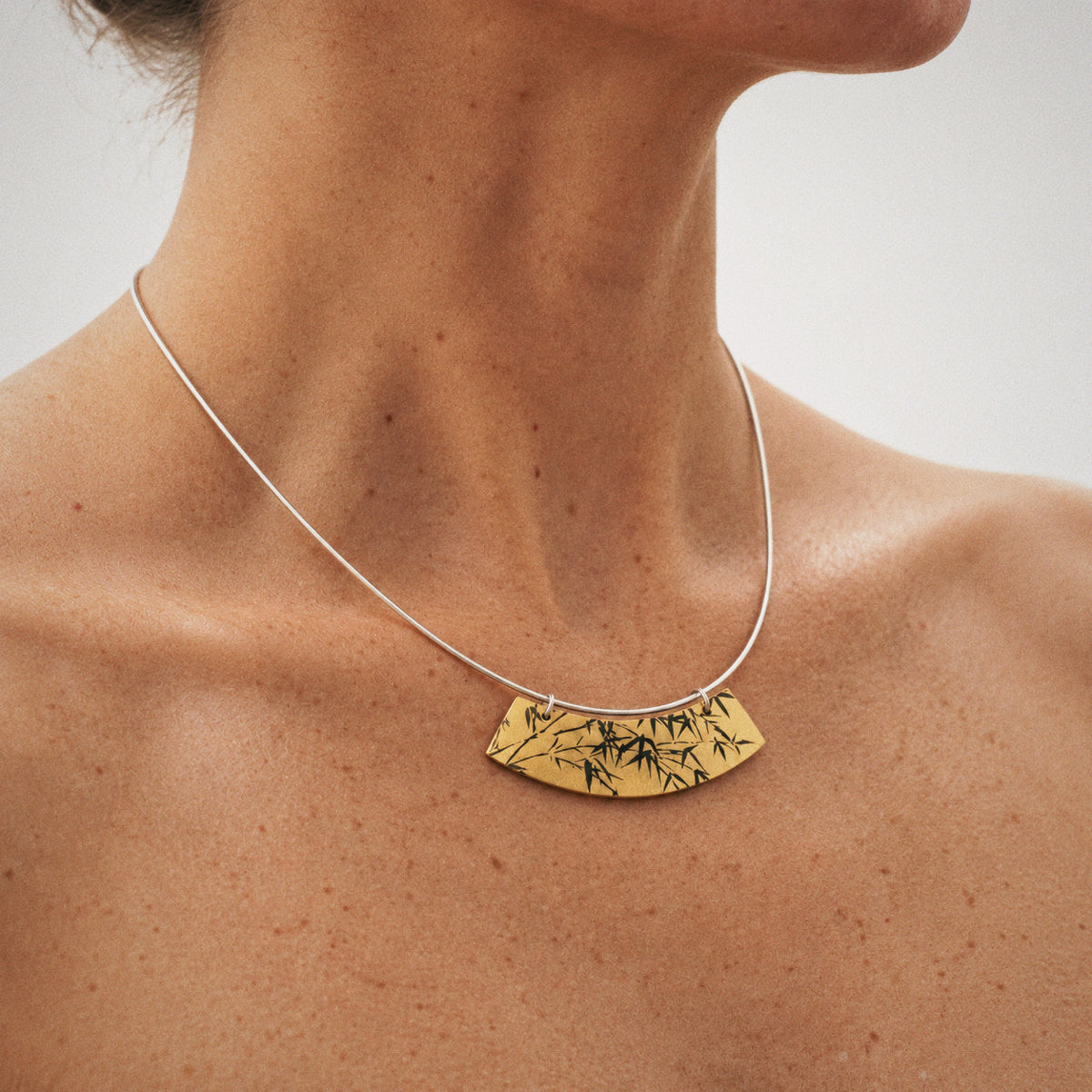 Close-up of the Lacquer Bamboo Collar Necklace, showing the finish and shape up close