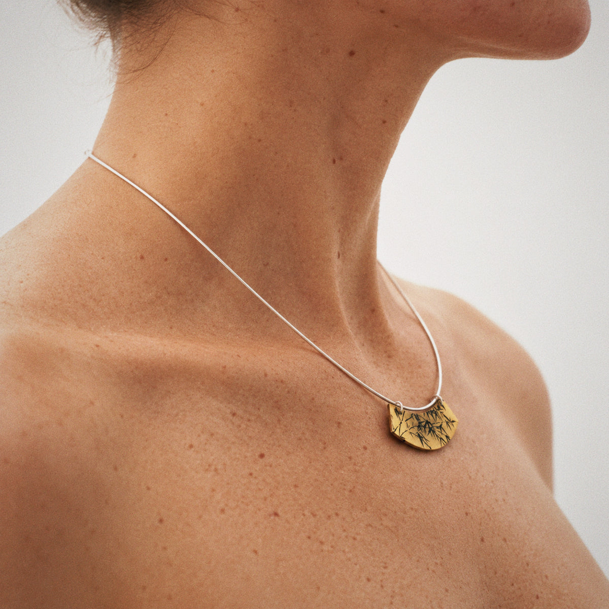 Lacquer Bamboo Collar Necklace styled at the collarbone with a plain black outfit