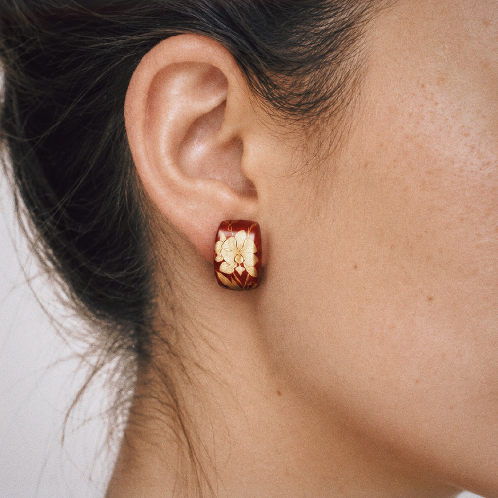 Maki-e Red Orchid Stud Earrings worn on the ear, red stud earrings