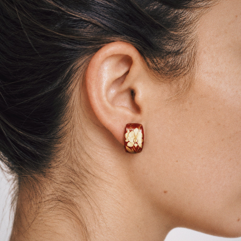 Close-up of the Maki-e Red Orchid Stud Earrings, showing the finish and shape up close