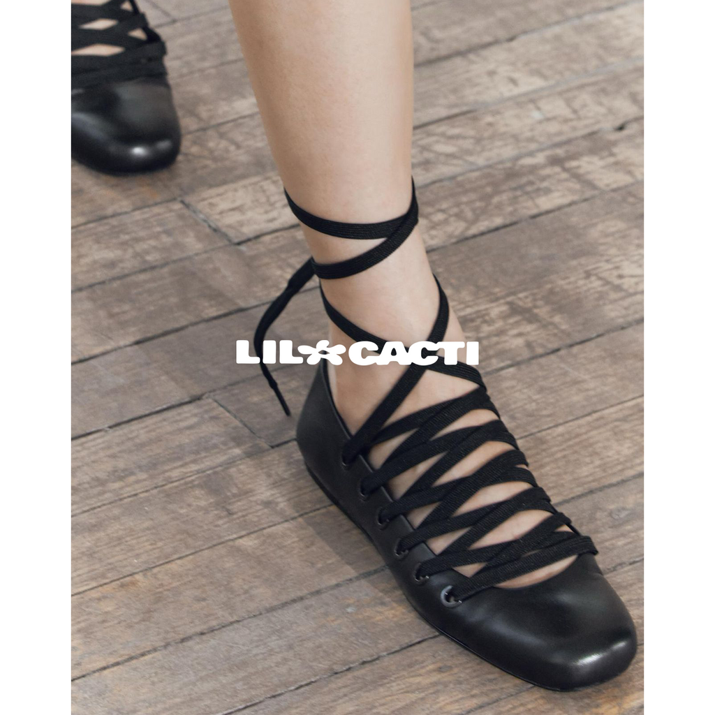 Black leather lace-up ballet flats worn on concrete — whimsigoth editorial style